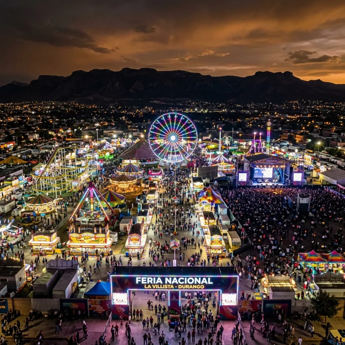 Vista panorámica aérea del recinto ferial FENADU Durango de noche, con juegos mecánicos, escenario y miles de luces